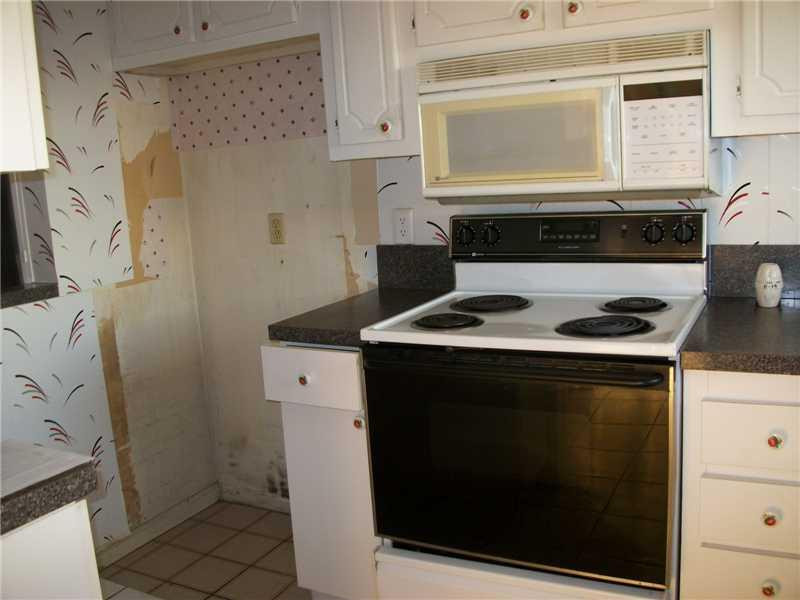 9949 Sandalfoot Boulevard, Unit 542 Boca Raton, FL 33428 - Photo 2 of 8 a kitchen with a stove and a microwave
