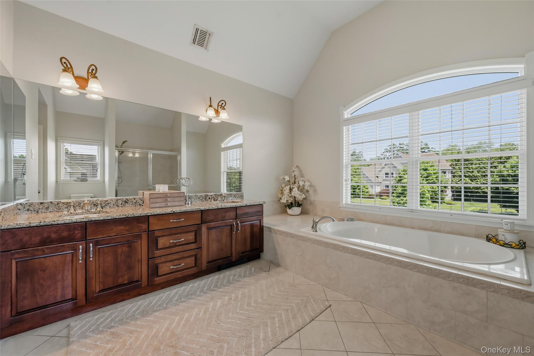 51 Meriwether Trail Congers, NY 10920 - Photo 25 of 50 Spacious bathroom featuring a large soaking tub with tiled surround, a double vanity with stone countertop, and an expansive arched window