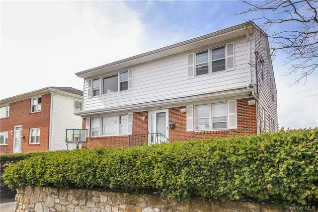 a front view of a house with a garden