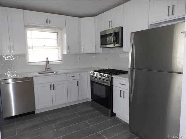 a kitchen with stainless steel appliances a refrigerator stove and sink