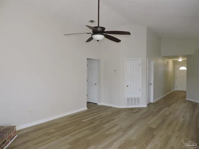 a view of a room with wooden floor and ceiling fan