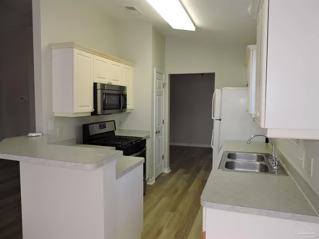 a kitchen that has a sink and a stove in it