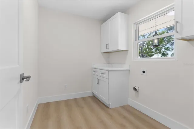 an empty room with windows and ceiling fan view