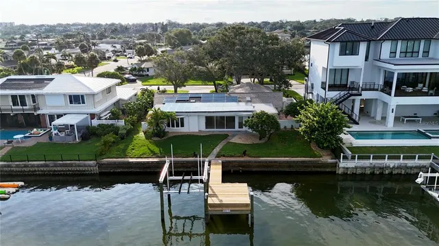 an aerial view of residential houses with outdoor space and lake view
