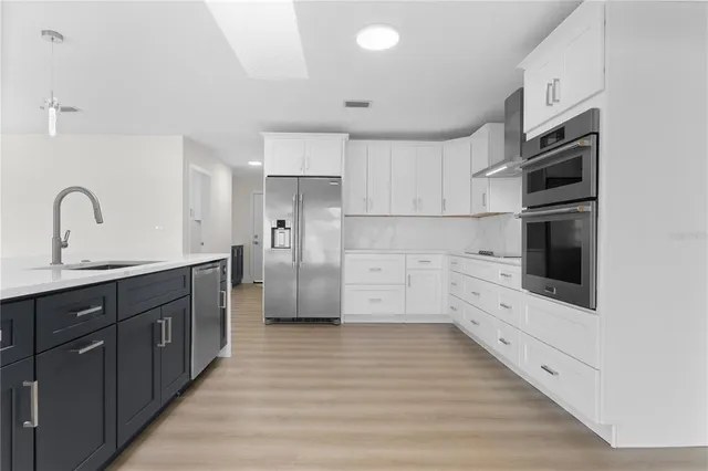 a kitchen with stainless steel appliances a refrigerator and a stove top oven