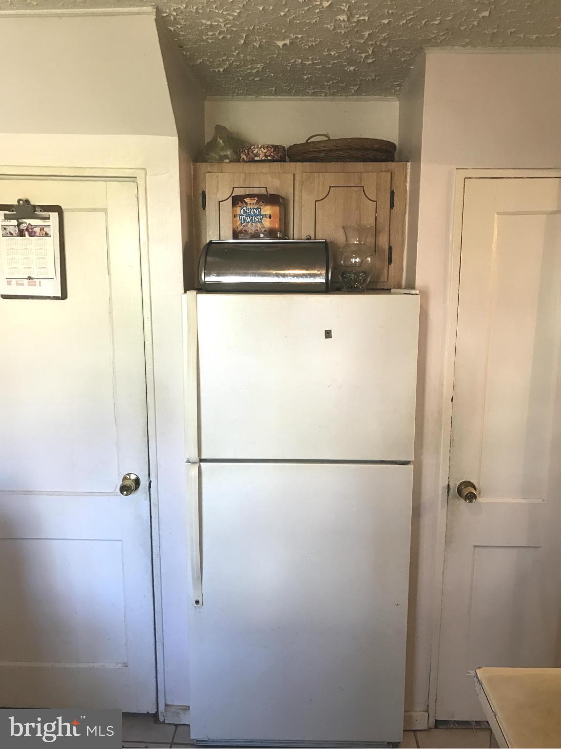 12055 Claridge Road Silver Spring, MD 20902 - Photo 7 of 10 a white refrigerator freezer and a table in a kitchen