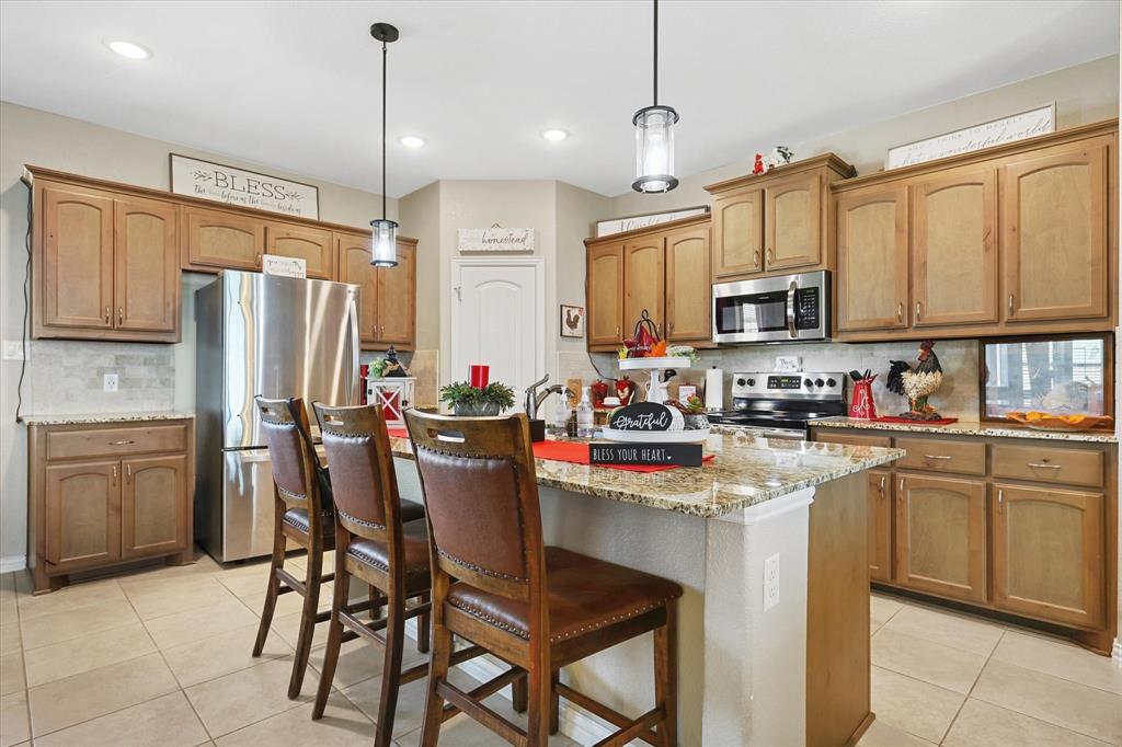 2375 County Road 4010 Decatur, TX 76234 - Photo 8 of 34 Kitchen with backsplash, light tile patterned flooring, stainless steel appliances, light stone countertops, and recessed lighting