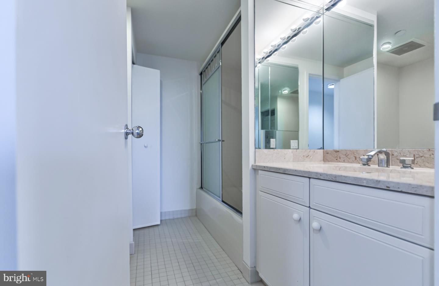 202-10 West Rittenhouse Square, Unit 1705 Philadelphia, PA 19103 - Photo 16 of 28 a bathroom with a granite countertop sink a mirror and a shower