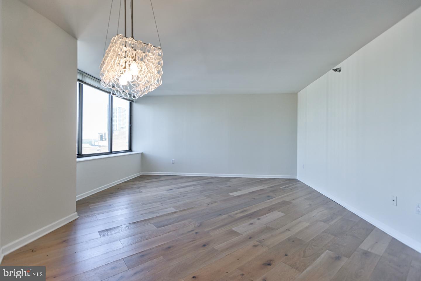 202-10 West Rittenhouse Square, Unit 1705 Philadelphia, PA 19103 - Photo 4 of 28 a view of an empty room with a chandelier fan and wooden floor