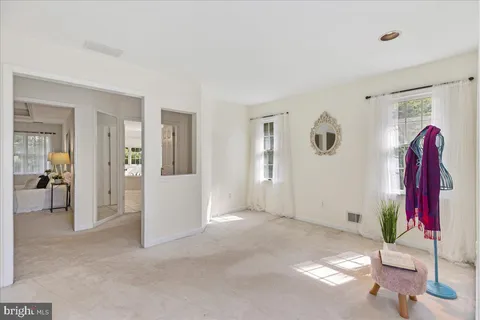 a view of a livingroom with wooden furniture and a ceiling fan