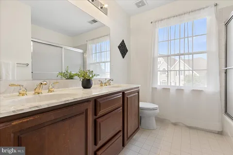 a bathroom with a double vanity sink toilet and a mirror
