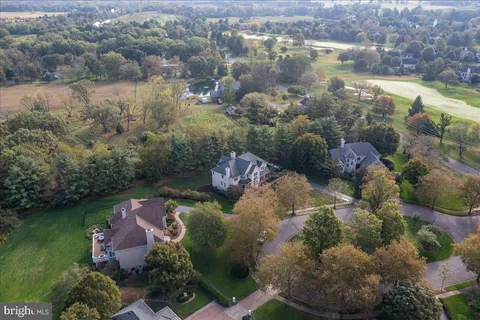 a front view of a house with a yard and large trees