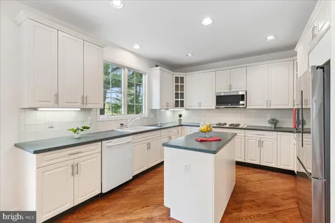 a kitchen with stainless steel appliances granite countertop a stove sink and cabinets