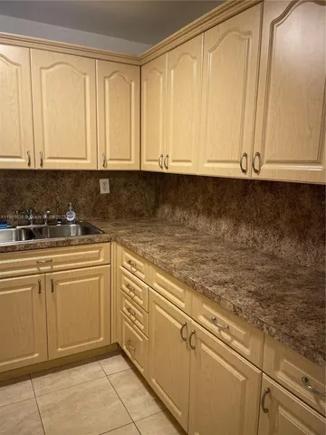 a kitchen with a refrigerator sink and cabinets