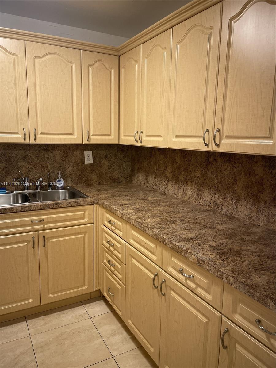1305 West 46th Street, Unit 112 Hialeah, FL 33012 - Photo 3 of 11 a kitchen with granite countertop white cabinets and sink