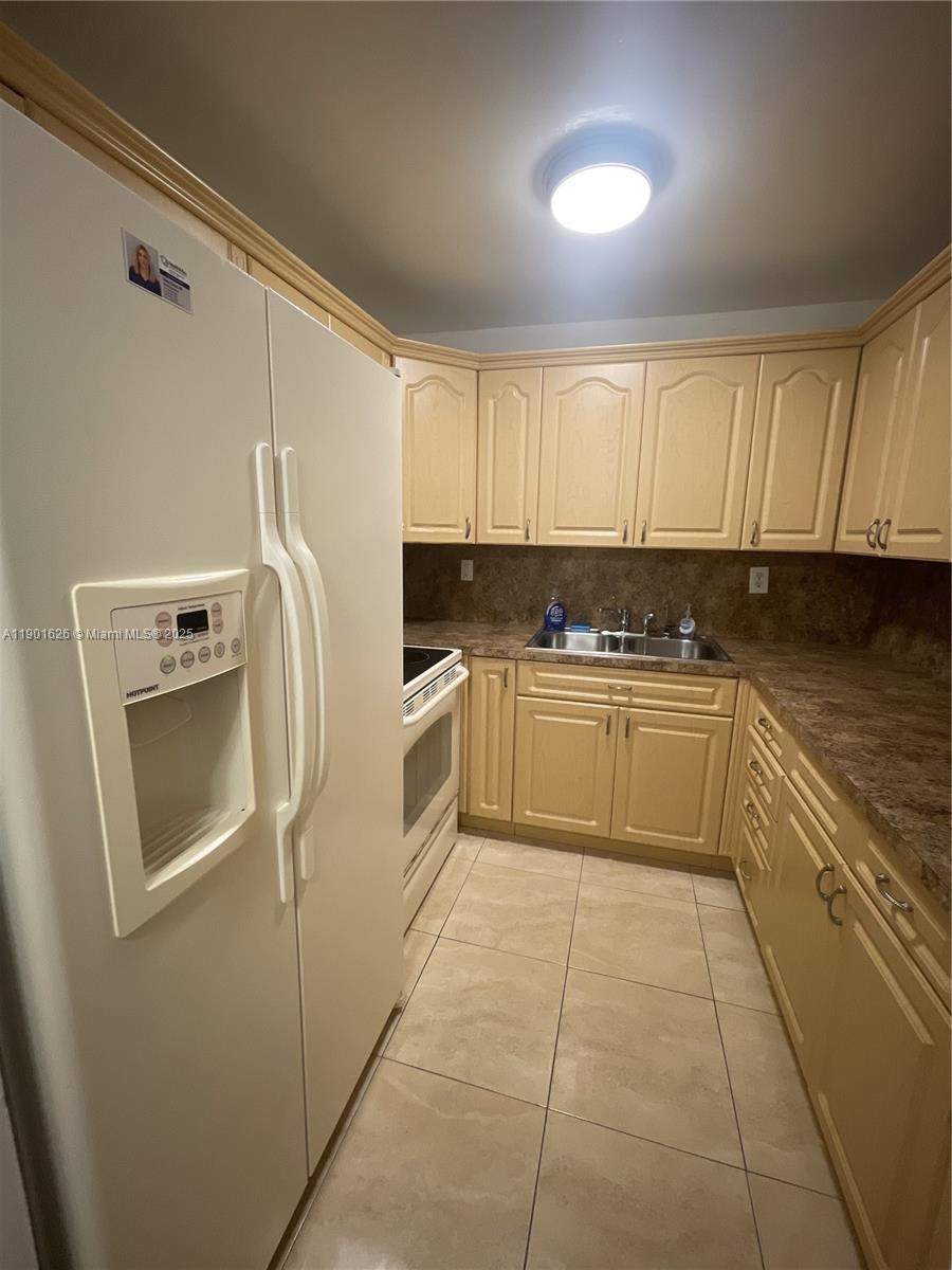 1305 West 46th Street, Unit 112 Hialeah, FL 33012 - Photo 4 of 11 a kitchen with a refrigerator sink and cabinets