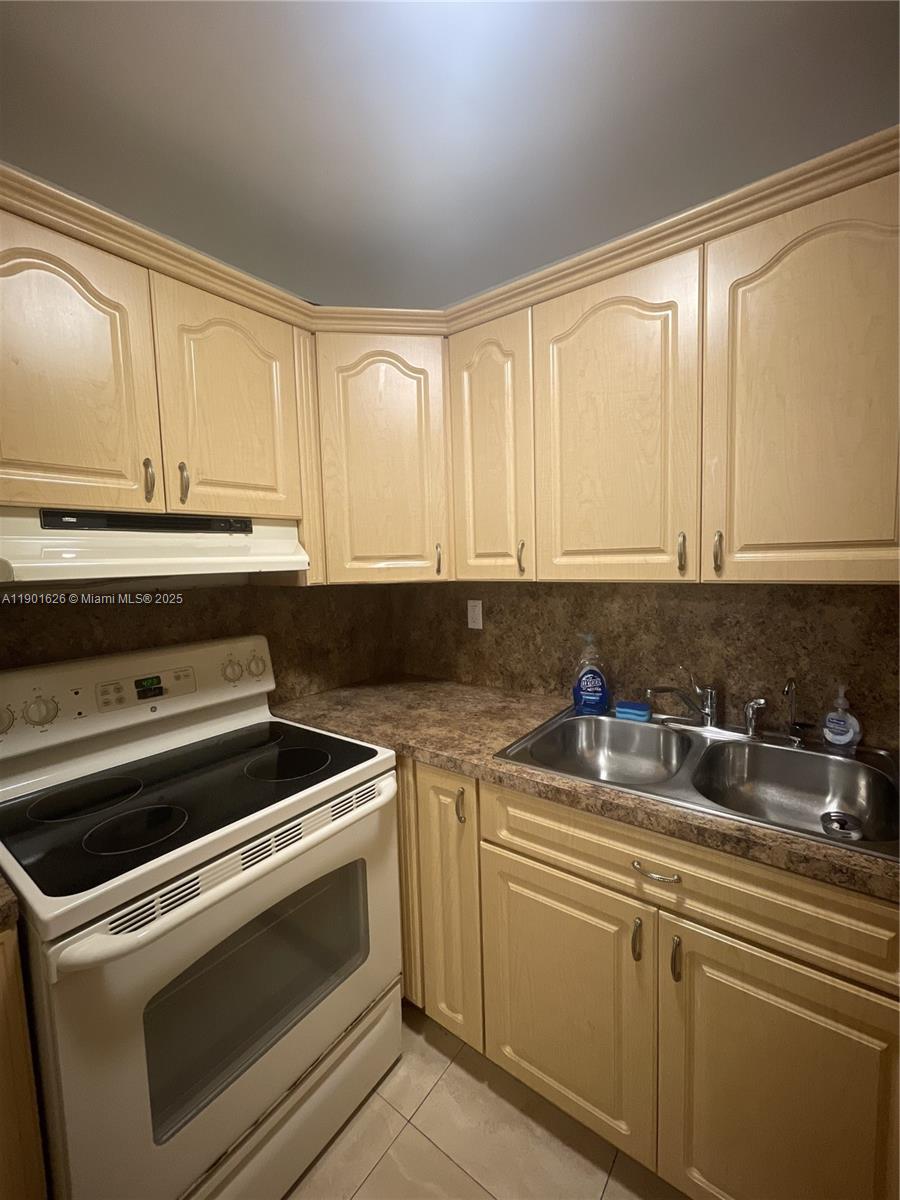 1305 West 46th Street, Unit 112 Hialeah, FL 33012 - Photo 5 of 11 a kitchen with a sink stove and cabinets