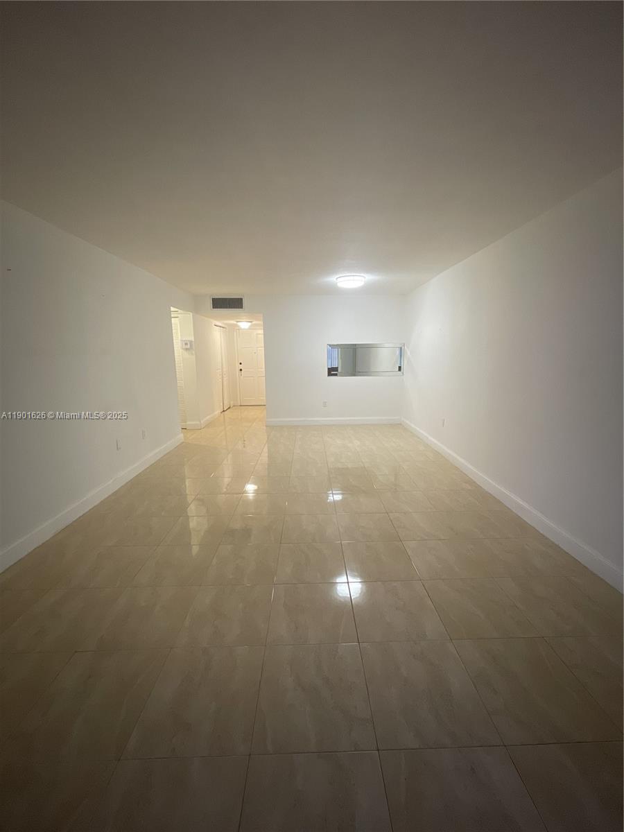 1305 West 46th Street, Unit 112 Hialeah, FL 33012 - Photo 7 of 11 a view of a room with an empty space and a window