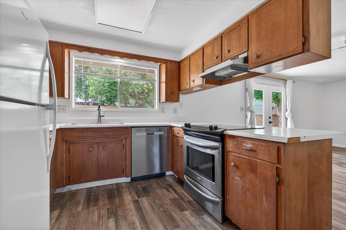 415 Sutter Avenue Medford, OR 97504 - Photo 8 of 28 a kitchen with stainless steel appliances granite countertop a sink a stove and wooden cabinets