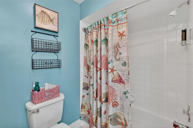 a bathroom with a toilet and a shower curtain