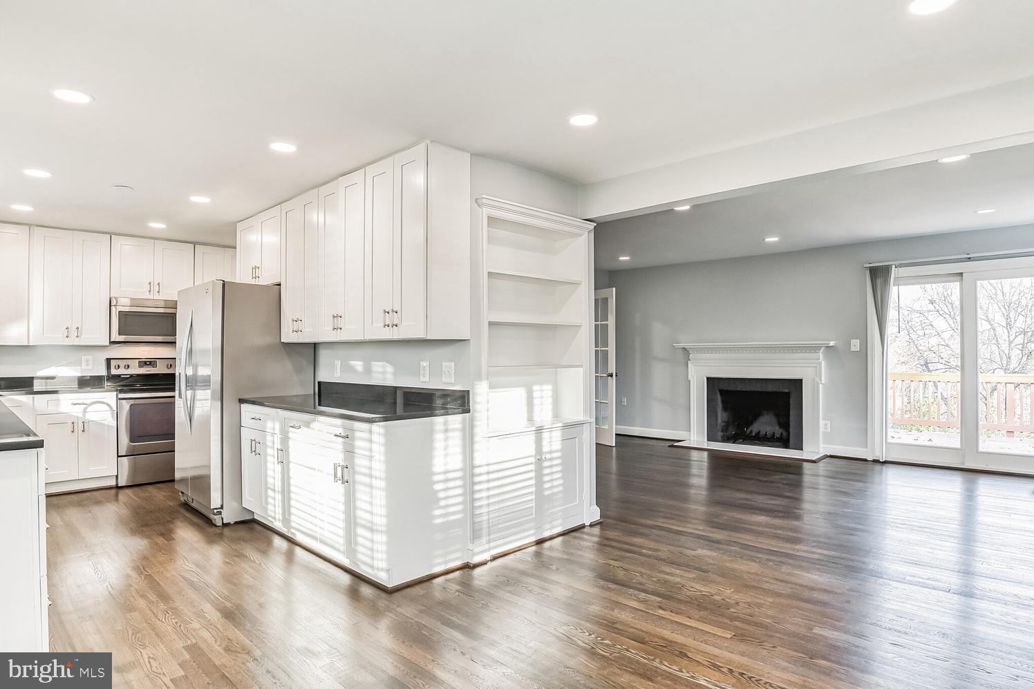 7016 Donna Circle Annandale, VA 22003 - Photo 6 of 30 a kitchen with wooden floors and white cabinets