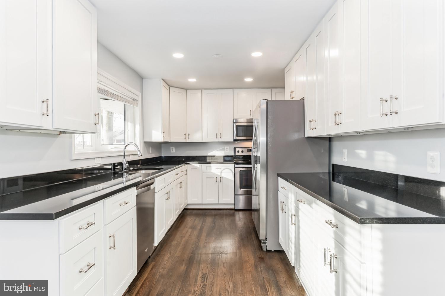 7016 Donna Circle Annandale, VA 22003 - Photo 7 of 30 a kitchen with granite countertop white cabinets and white appliances