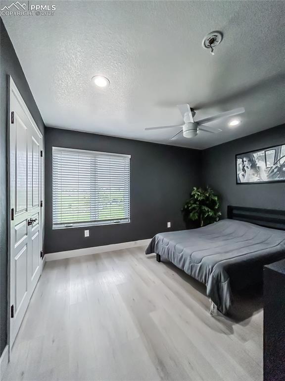 13435 Hodgen Road Elbert, CO 80106 - Photo 12 of 24 a spacious bedroom with a large bed and a chandelier