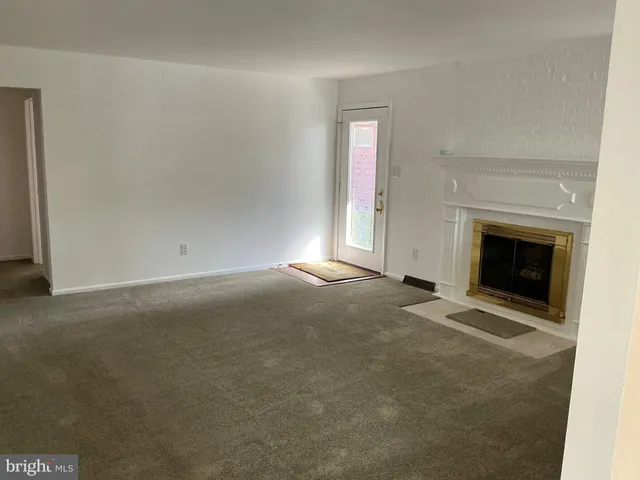 a view of empty room with a fireplace