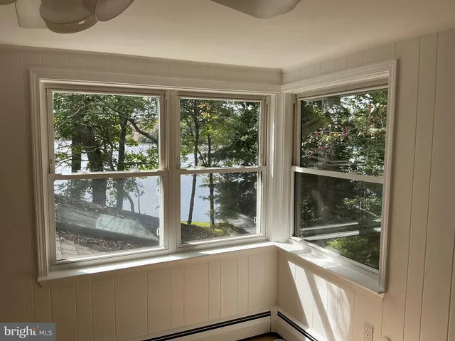 a view of a room with a large window and wooden floor