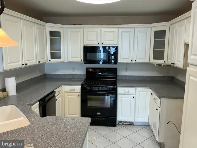 a kitchen with granite countertop a stove a sink and a microwave