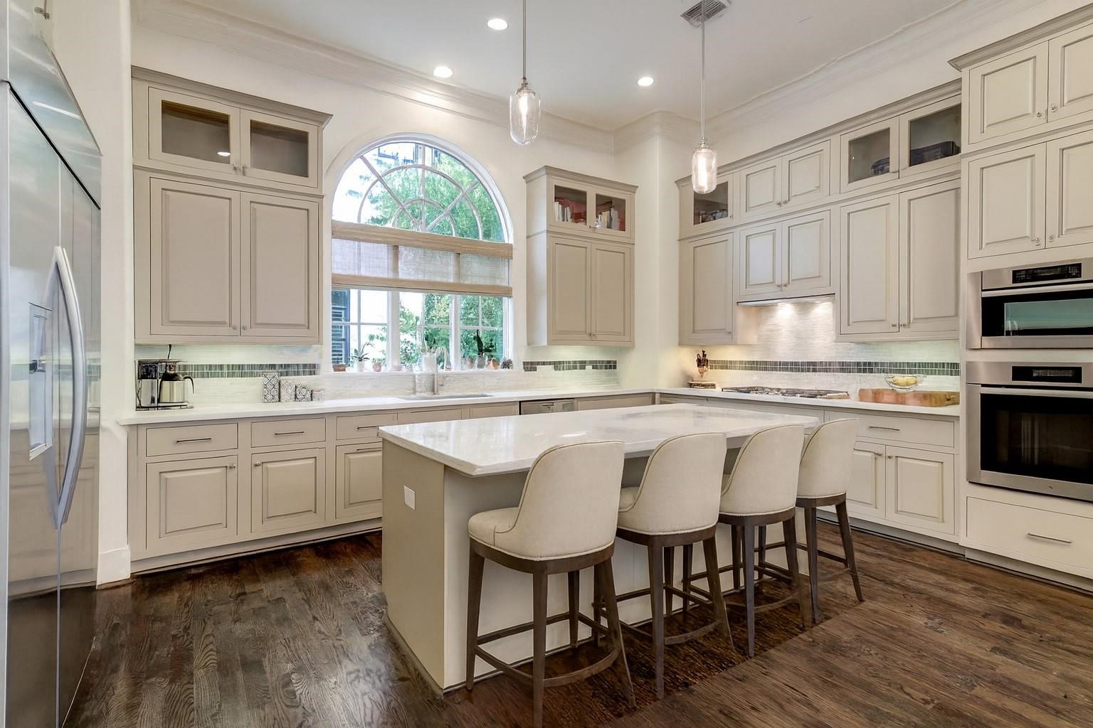 5218 Crawford Street Houston, TX 77004 - Photo 6 of 22 a kitchen with stainless steel appliances granite countertop a stove a sink dishwasher a dining table and chairs with wooden floor