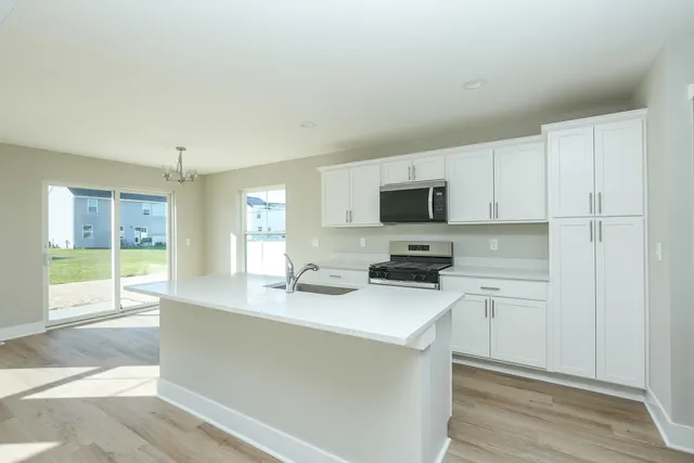a kitchen with stainless steel appliances granite countertop a sink stove and cabinets