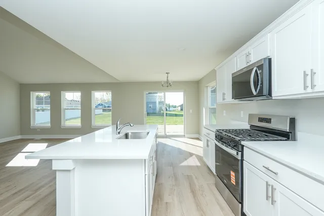 a kitchen with a sink a chandelier fan and wooden floor
