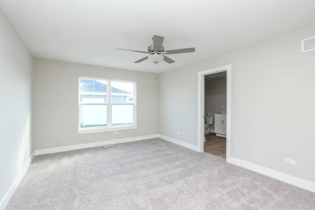 an empty room with a ceiling fan and window