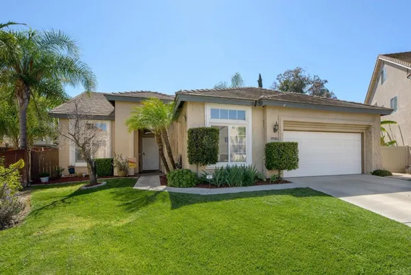 a front view of a house with a yard and potted plants