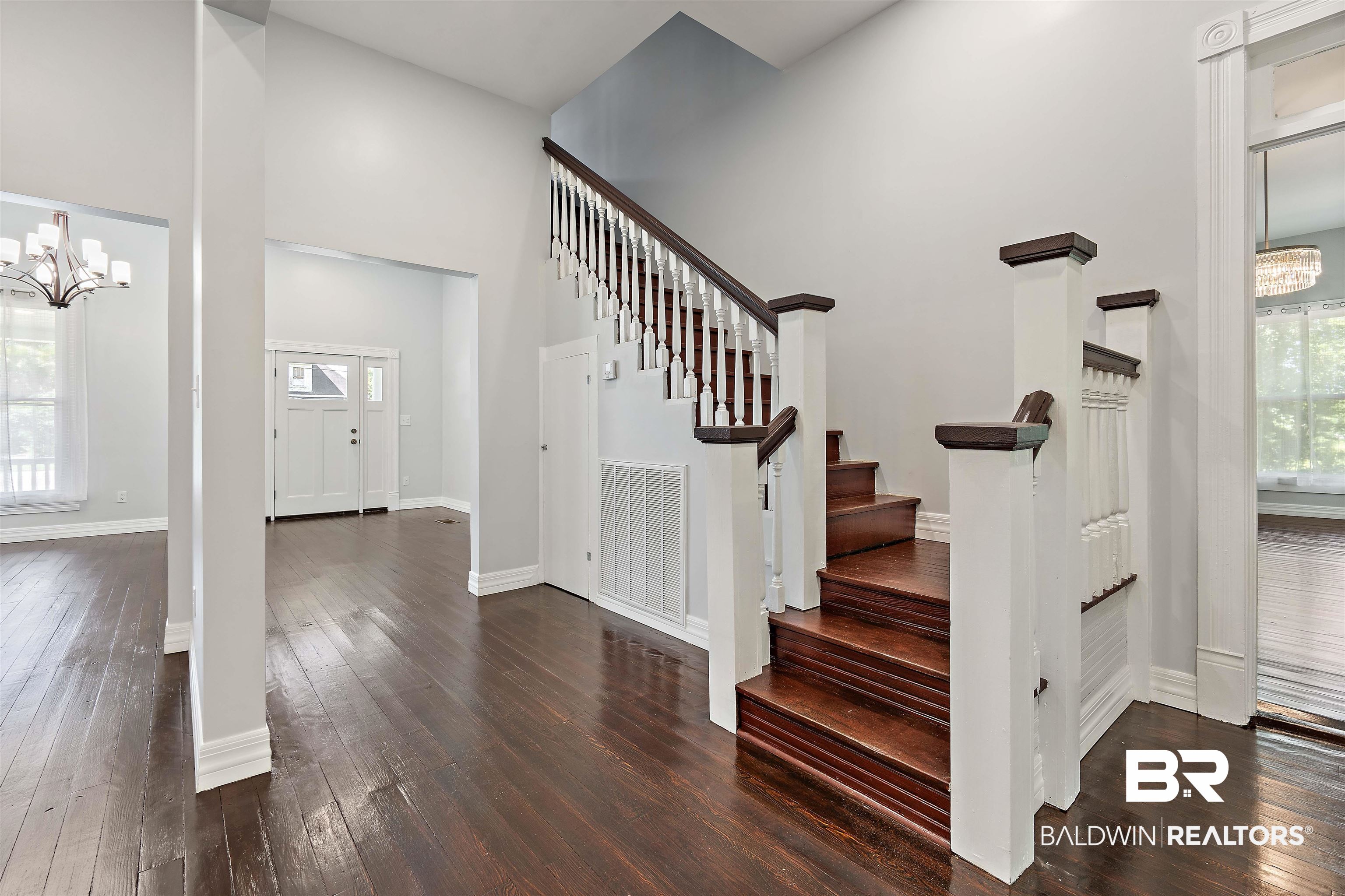 407 East 2nd Street Bay Minette, AL 36507 - Photo 26 of 40 Entryway featuring a towering ceiling, a chandelier, dark wood finished floors, and stairway