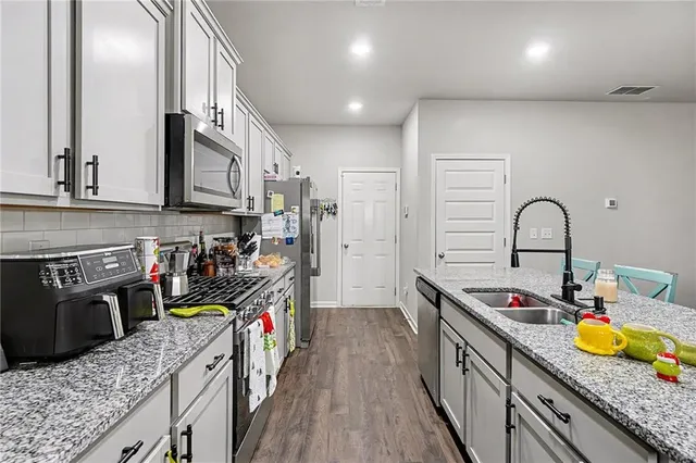 a kitchen with lots of counter top space and wooden floor