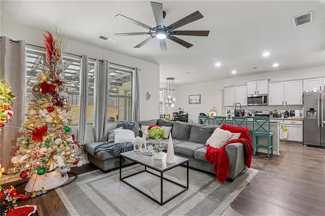a living room with furniture kitchen view and a potted plant