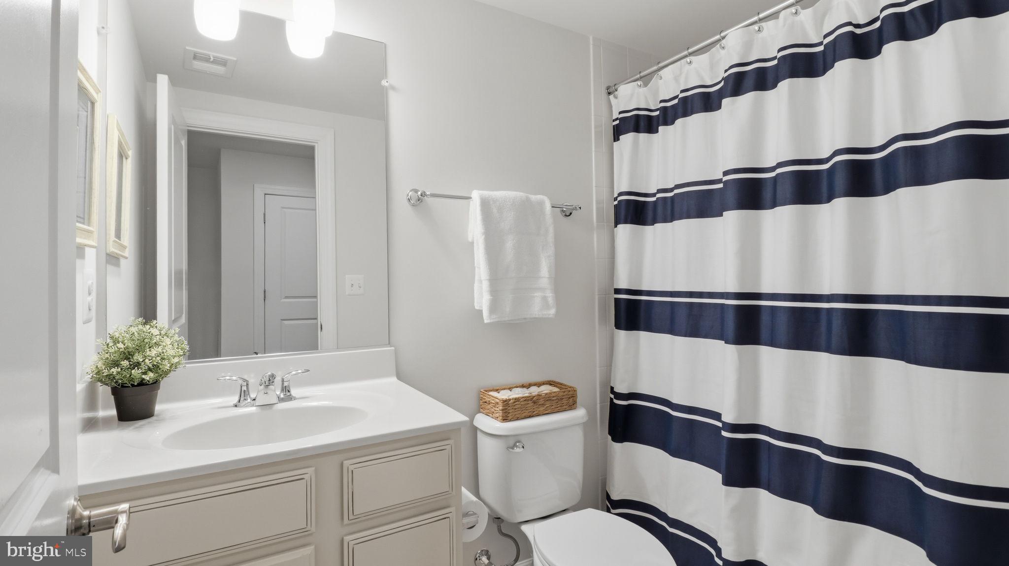 13806 Litespeed Way Gainesville, VA 20155 - Photo 18 of 22 a bathroom with a sink a toilet and shower curtain