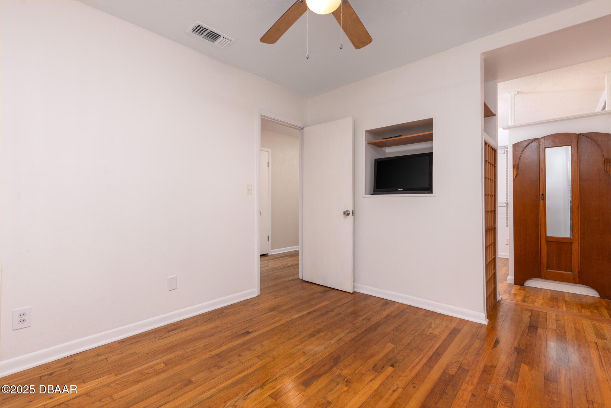 7915 Breezy Point Road East, Unit W Melrose, FL 32666 - Photo 13 of 36 an empty room with wooden floor and windows