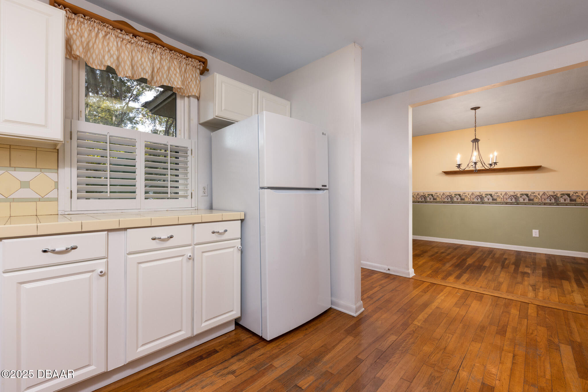 7915 Breezy Point Road East, Unit W Melrose, FL 32666 - Photo 27 of 36 a kitchen with granite countertop white cabinets and white appliances