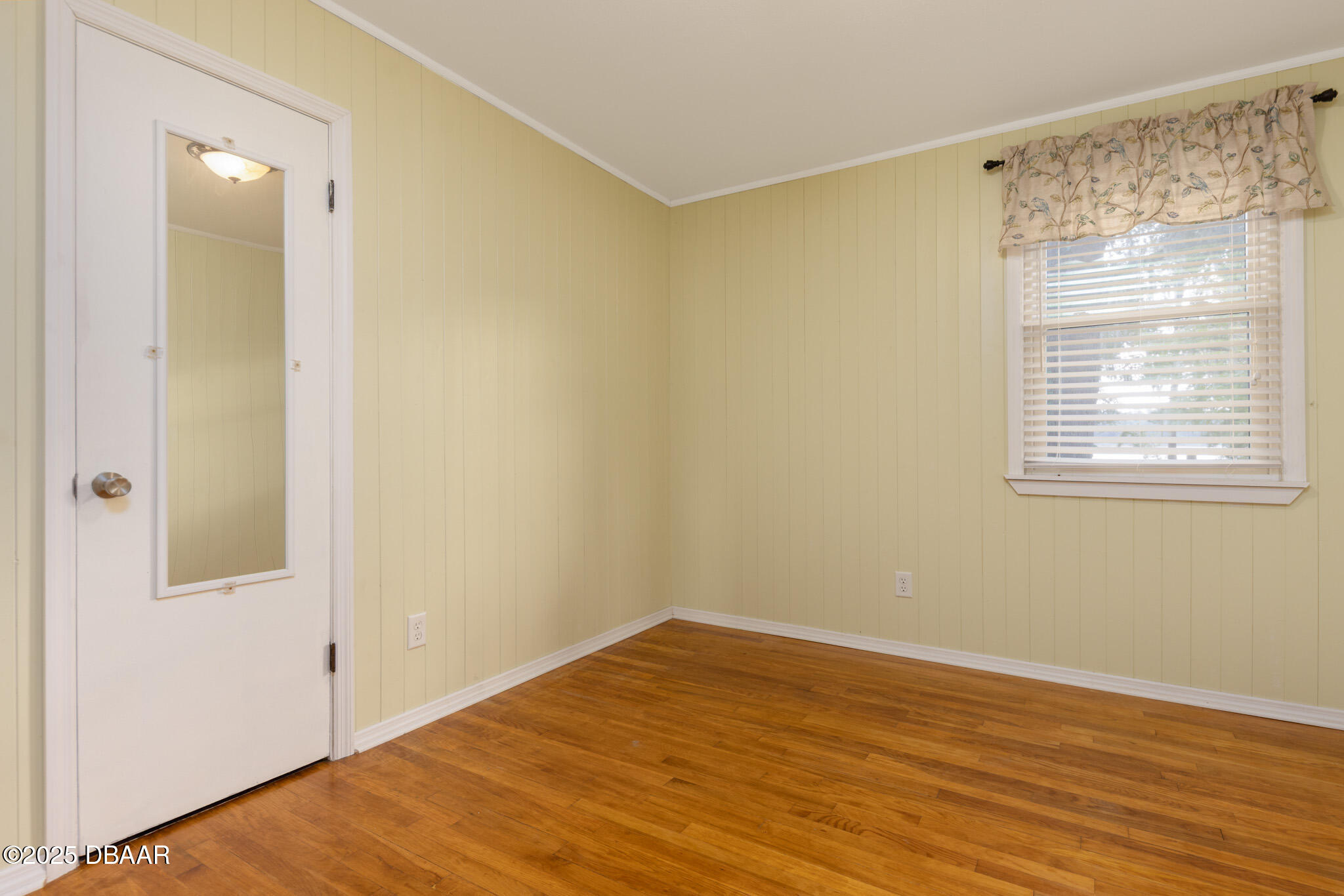 7915 Breezy Point Road East, Unit W Melrose, FL 32666 - Photo 7 of 36 a view of an empty room with wooden floor and a window