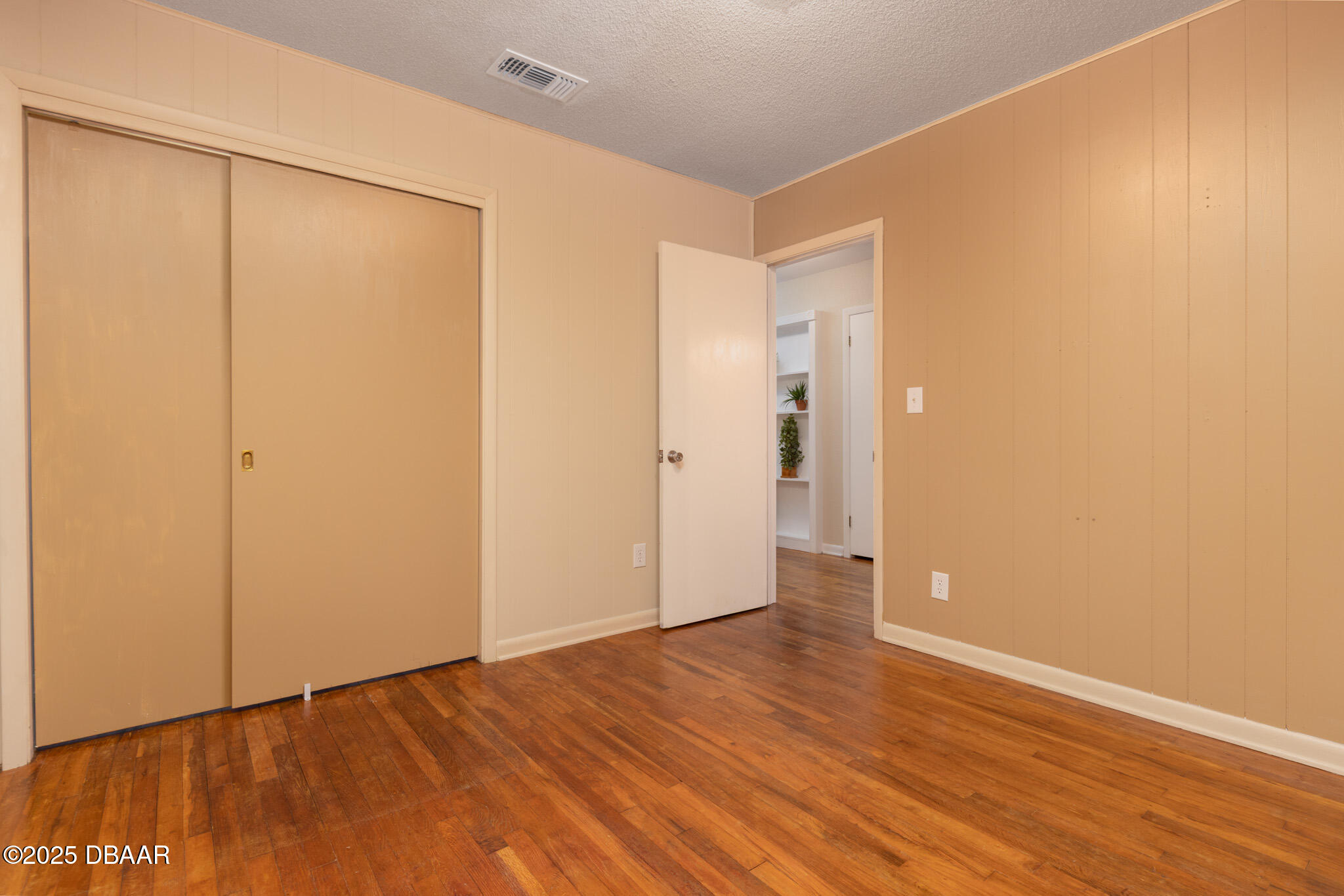 7915 Breezy Point Road East, Unit W Melrose, FL 32666 - Photo 9 of 36 a view of an empty room with wooden floor