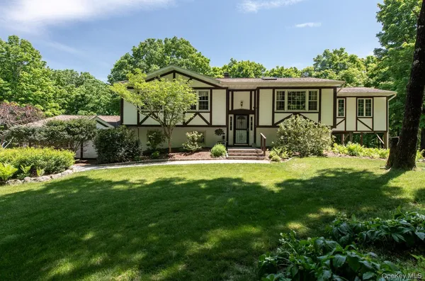 a view of a house with a yard and potted plants
