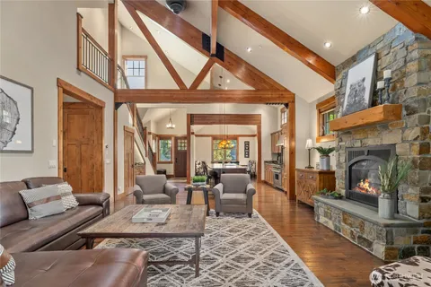 a living room with furniture a fireplace and large windows