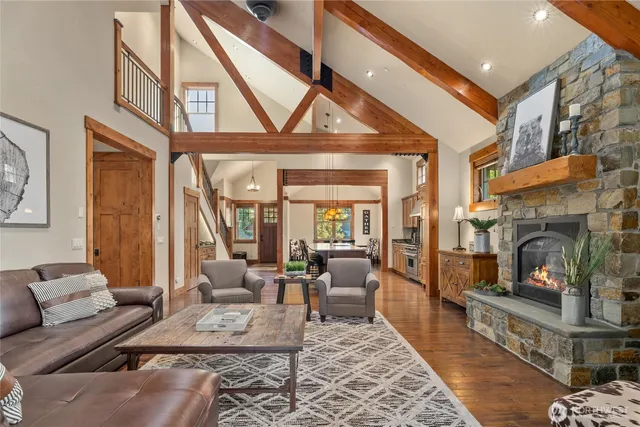 a living room with furniture a fireplace and large windows