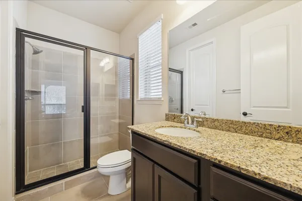 a bathroom with a granite countertop sink toilet and shower