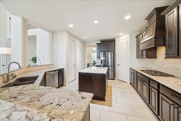 a large kitchen with stainless steel appliances kitchen island granite countertop a sink and cabinets