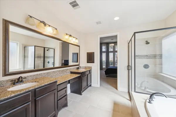 a bathroom with a granite countertop tub sink double vanity granite and a large mirror