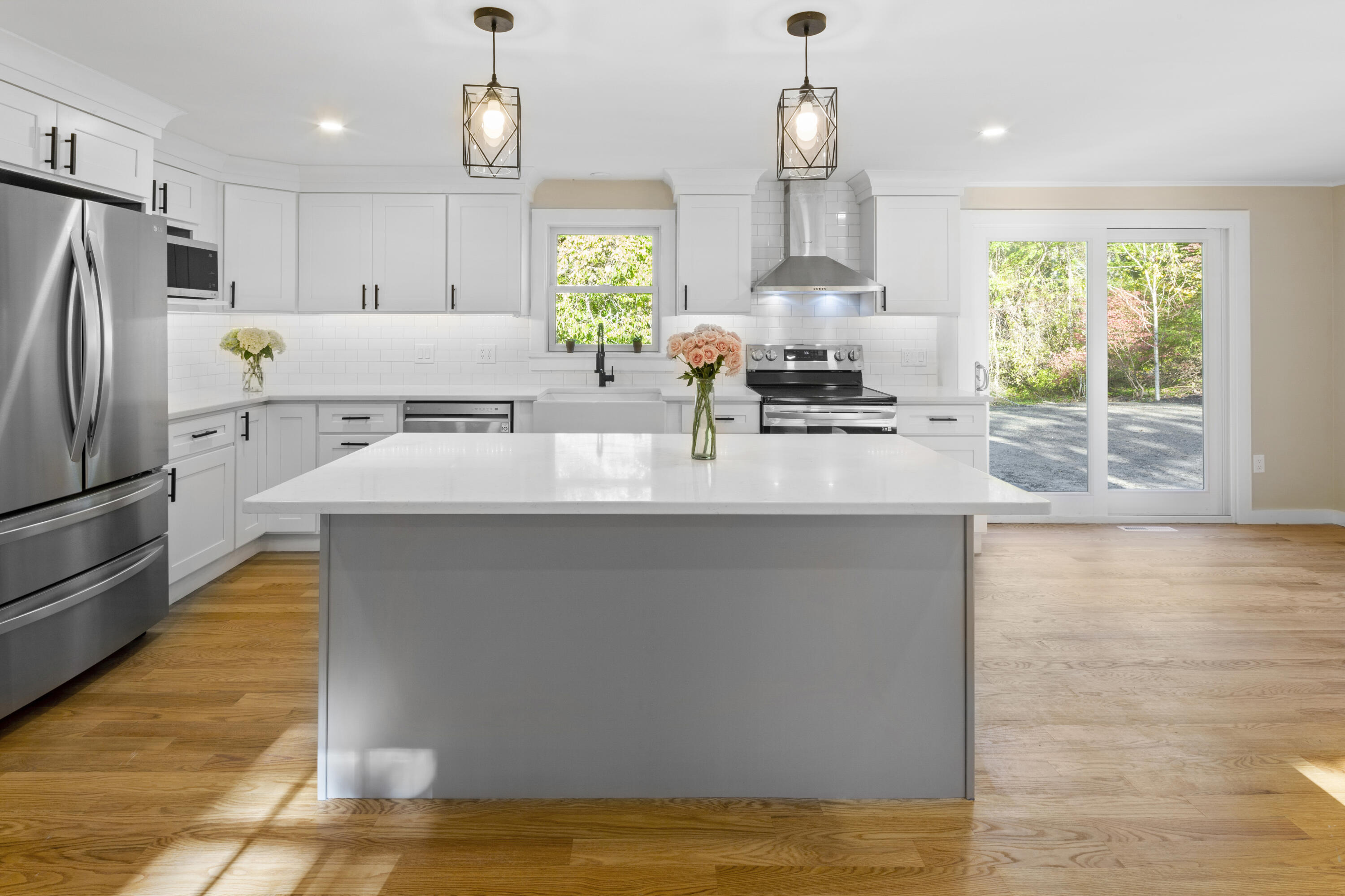 a kitchen with kitchen island a counter top space a sink stainless steel appliances and cabinets